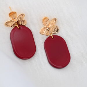 Burgundy oorbellen met goudkleurige bloemvormige oorstekers en afgeronde hangers van acetate