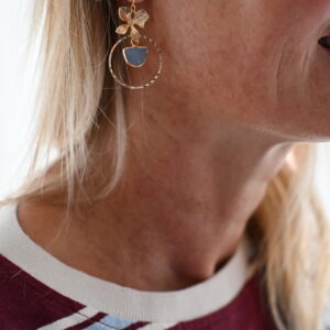 Goudkleurige oorhangers met bloem, ronde hanger en blauw steentje