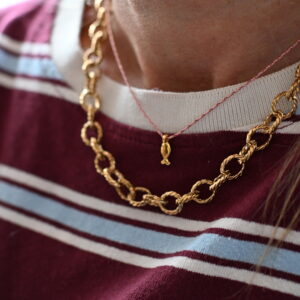Goudkleurige schakelketting met gedraaide ovale schakels gedragen rond de hals